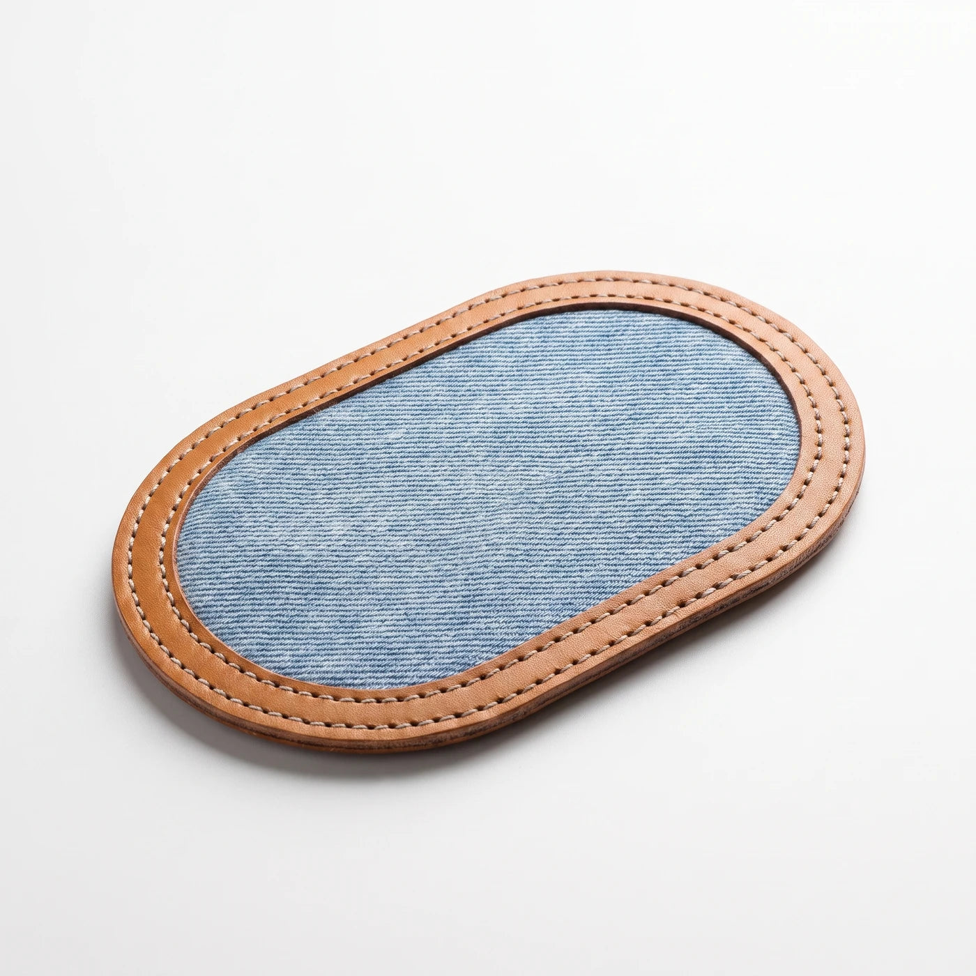The denim side of the strop, framed by the stitched leather border
