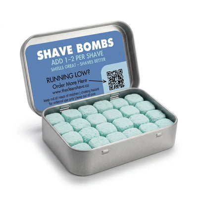 An open silver tin of pale teal Shave Bomb tablets